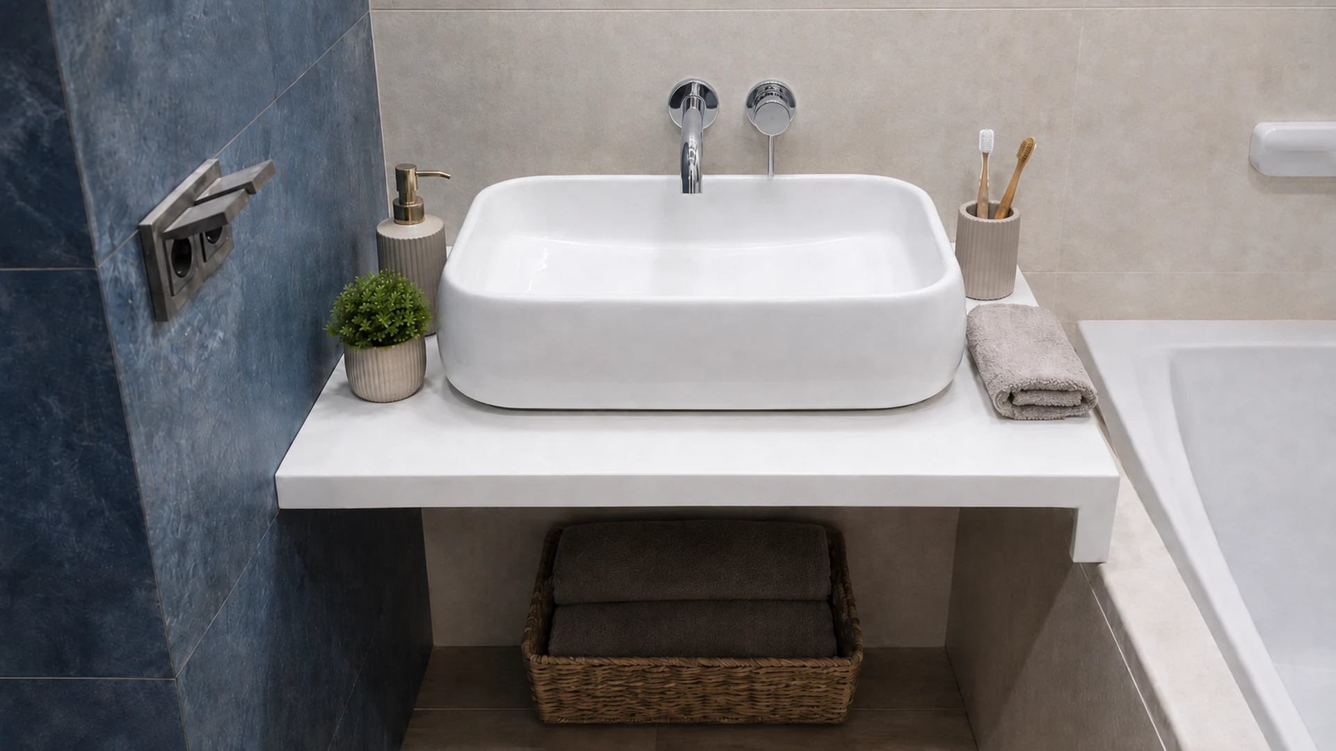 White countertop basin on an open console with a wall-mounted chrome tap and towel basket.