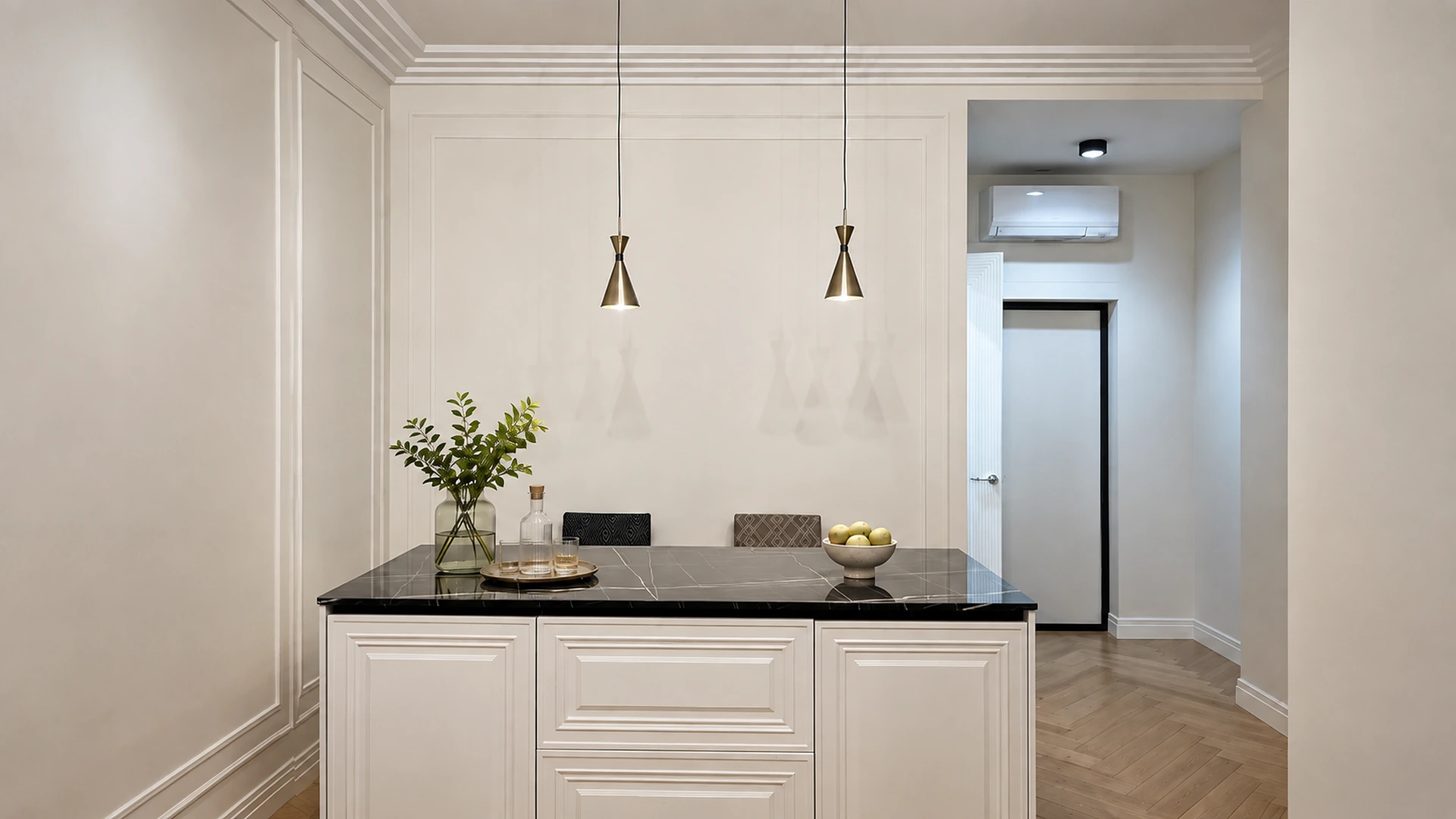 Classic kitchen island with white framed fronts, black stone countertop and brass pendant lights.
